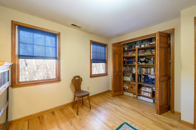 living area featuring a textured ceiling and light hardwood / wood-style flooring