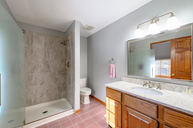 bathroom featuring vanity, toilet, and tiled shower