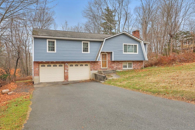 bi-level home featuring a garage and a front lawn