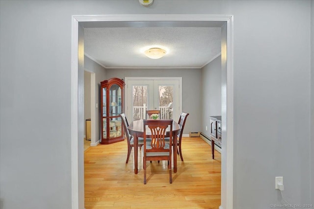 dining space with french doors, a textured ceiling, and light hardwood / wood-style flooring