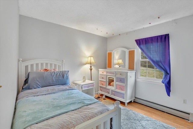 bedroom featuring hardwood / wood-style floors, a baseboard radiator, and a textured ceiling