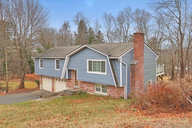 split foyer home featuring a garage and a front yard