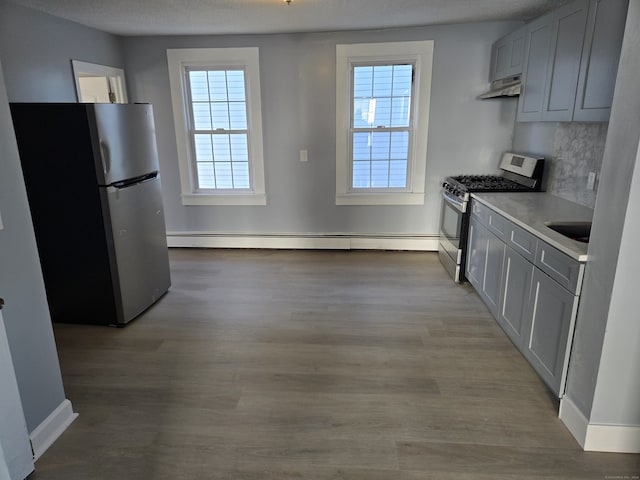 kitchen with appliances with stainless steel finishes, ventilation hood, plenty of natural light, and light hardwood / wood-style floors