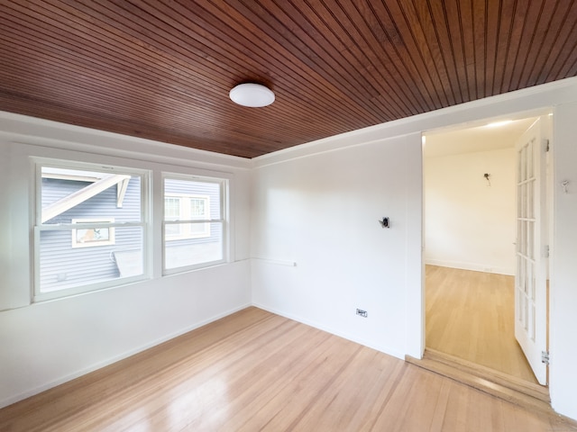 empty room with light hardwood / wood-style floors and wooden ceiling