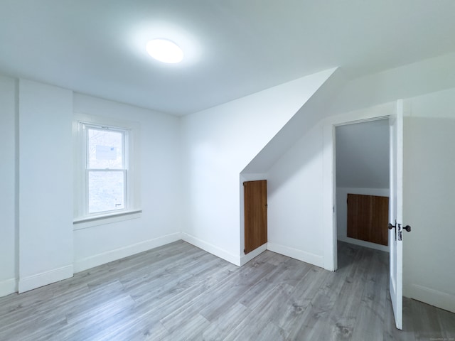 additional living space with light hardwood / wood-style flooring