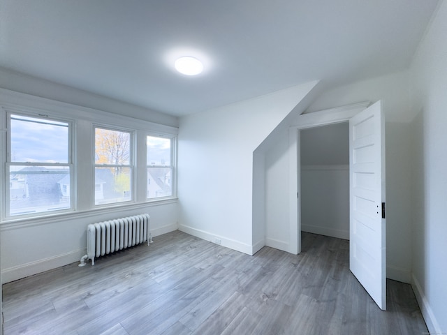 bonus room featuring radiator and hardwood / wood-style flooring