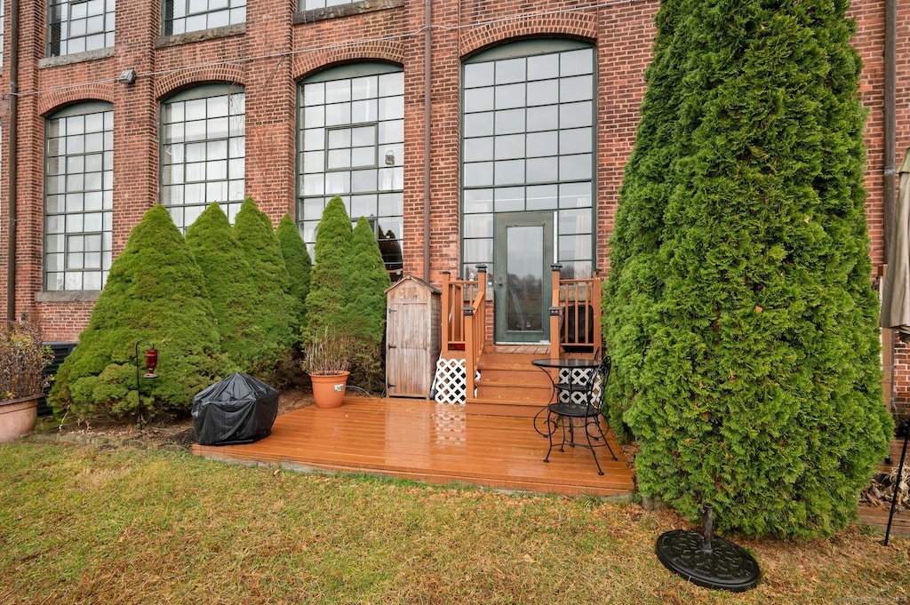 view of exterior entry featuring a deck and a yard