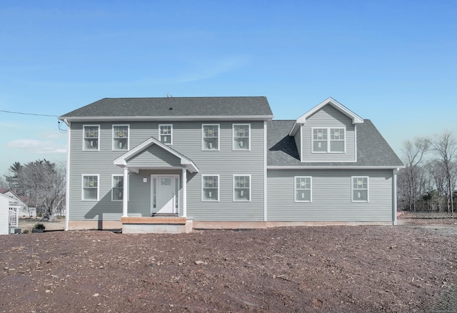 colonial-style house with roof with shingles