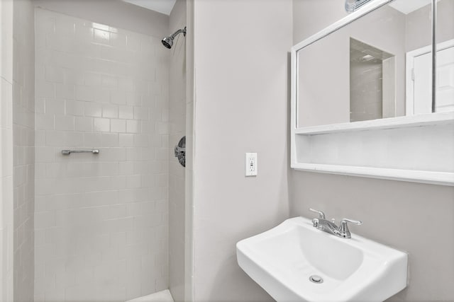 bathroom featuring a tile shower and sink