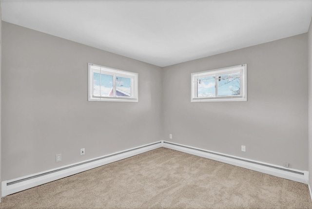 unfurnished room featuring plenty of natural light, light colored carpet, and a baseboard heating unit