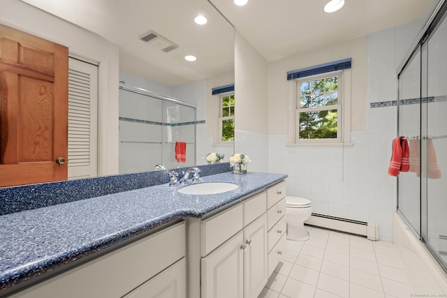 full bathroom featuring tile walls, vanity, a baseboard heating unit, toilet, and tile patterned floors