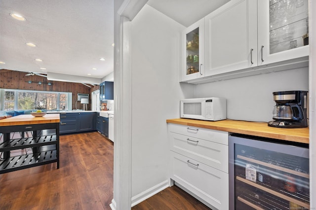 bar with white cabinets, dark hardwood / wood-style flooring, wine cooler, and butcher block countertops