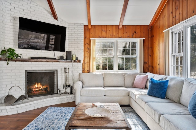 living room with a brick fireplace, wood-type flooring, lofted ceiling with beams, and wood walls