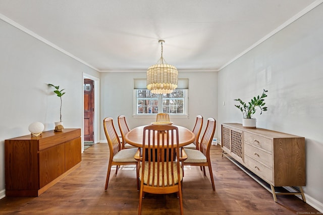 dining room with dark hardwood / wood-style flooring, crown molding, and a chandelier