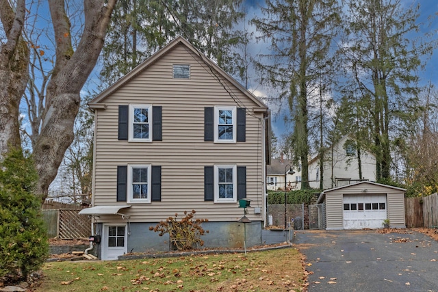 view of property with a front yard, an outdoor structure, and a garage