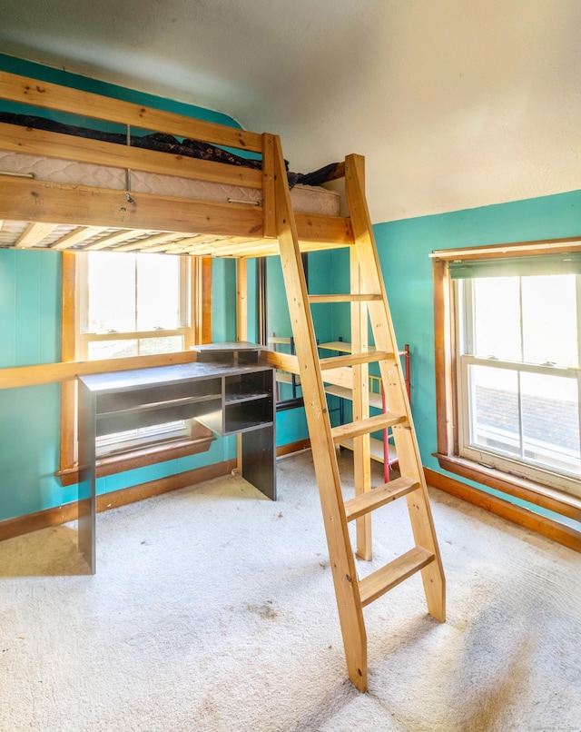 unfurnished bedroom featuring carpet flooring and multiple windows