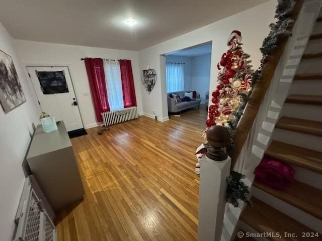 foyer entrance with radiator heating unit and light wood-type flooring