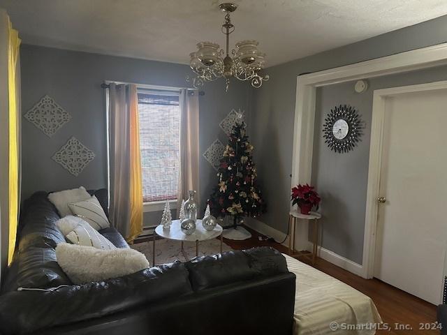 living room with dark hardwood / wood-style floors and an inviting chandelier