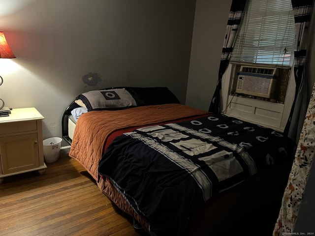 bedroom with cooling unit and light hardwood / wood-style flooring