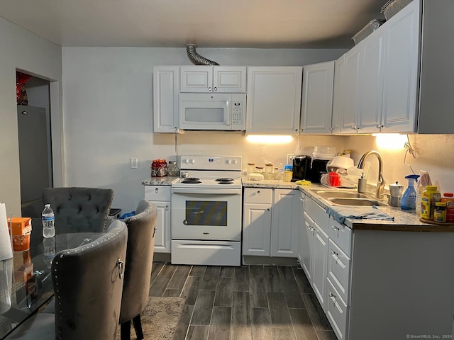 kitchen with white cabinets, dark hardwood / wood-style flooring, white appliances, and sink