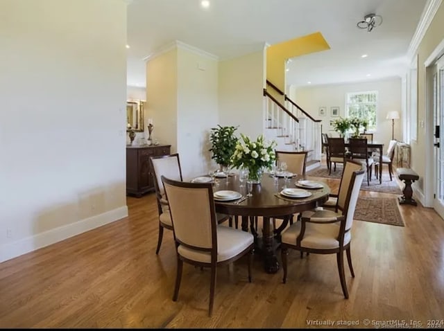 dining space featuring hardwood / wood-style floors and ornamental molding