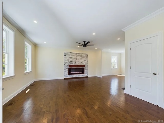 unfurnished living room with a stone fireplace, ceiling fan, dark hardwood / wood-style floors, and ornamental molding