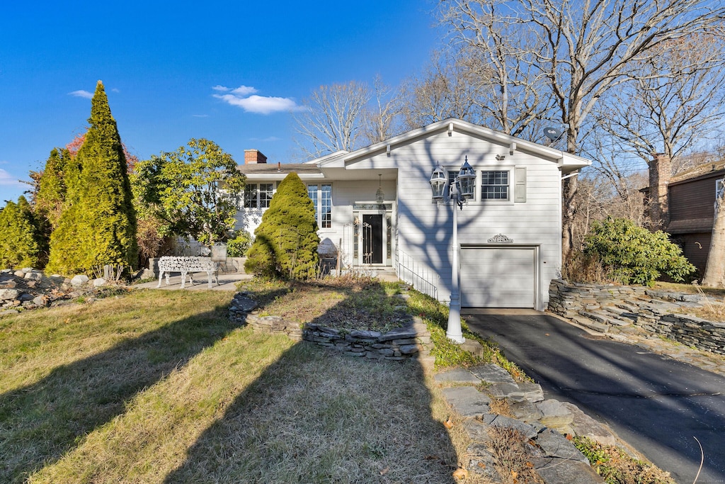 back of property featuring a garage and a yard