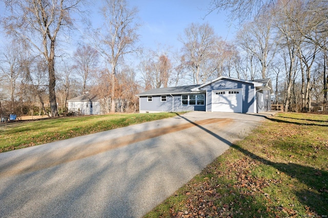 single story home featuring a front lawn and a garage