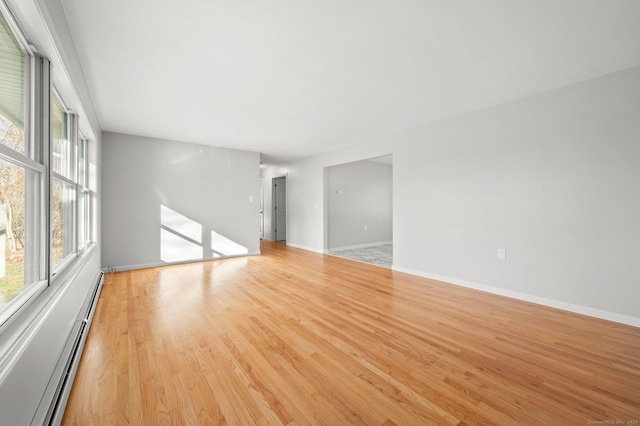 unfurnished room featuring light hardwood / wood-style floors and a baseboard heating unit