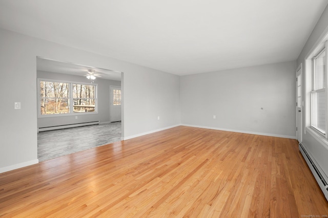 unfurnished room with light wood-type flooring, baseboard heating, and ceiling fan