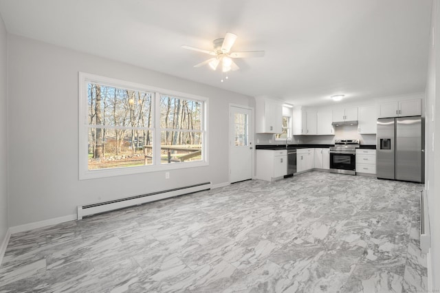 kitchen featuring stainless steel appliances, ceiling fan, sink, a baseboard radiator, and white cabinetry