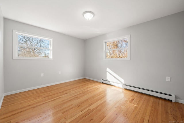 empty room with light hardwood / wood-style floors and baseboard heating