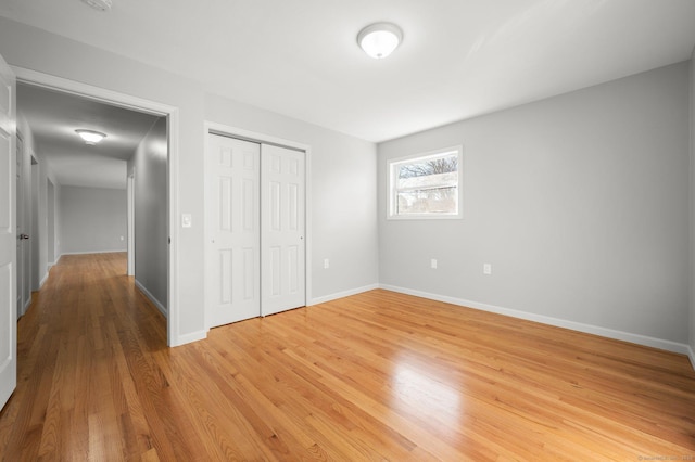 unfurnished bedroom with wood-type flooring and a closet