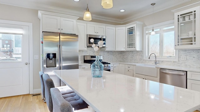 kitchen with decorative light fixtures, plenty of natural light, stainless steel appliances, and a breakfast bar area