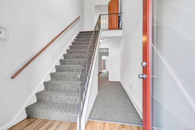 stairs with hardwood / wood-style flooring and a baseboard radiator