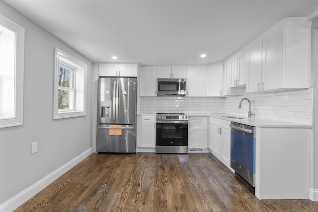 kitchen featuring white cabinets, sink, stainless steel appliances, and dark wood-type flooring