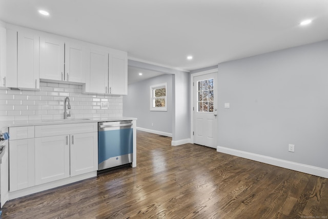 kitchen featuring decorative backsplash, stainless steel dishwasher, sink, dark hardwood / wood-style floors, and white cabinetry