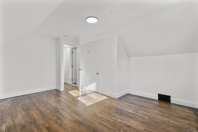 additional living space with dark hardwood / wood-style flooring and lofted ceiling