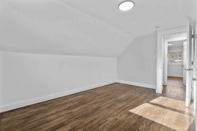 additional living space with dark hardwood / wood-style floors and lofted ceiling