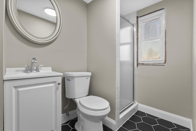 bathroom with tile patterned floors, a shower with door, vanity, and toilet