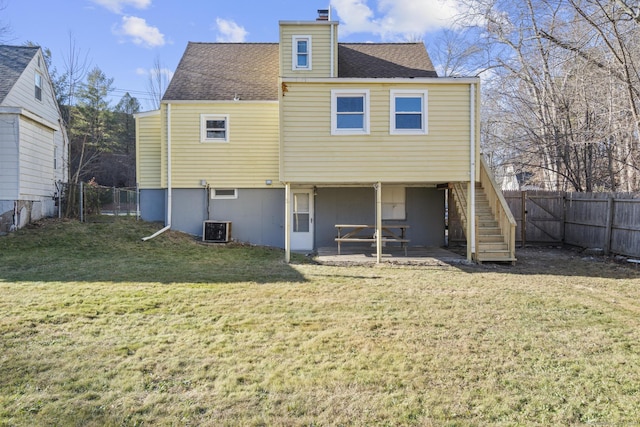 rear view of property featuring cooling unit and a lawn