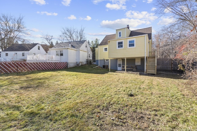 rear view of house with a lawn and central air condition unit