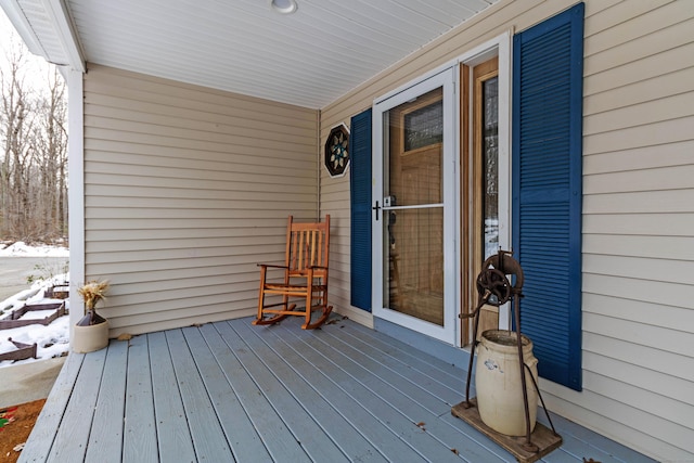 snow covered deck featuring covered porch