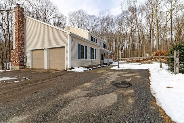 snow covered property with a garage