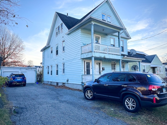 view of front of home with covered porch, a balcony, and a garage