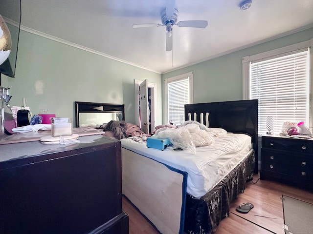 bedroom featuring wood-type flooring, ceiling fan, and crown molding