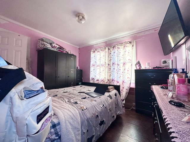 bedroom with dark hardwood / wood-style floors and ornamental molding