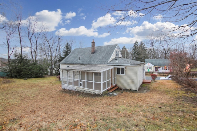 rear view of property with a lawn, a wooden deck, and a sunroom