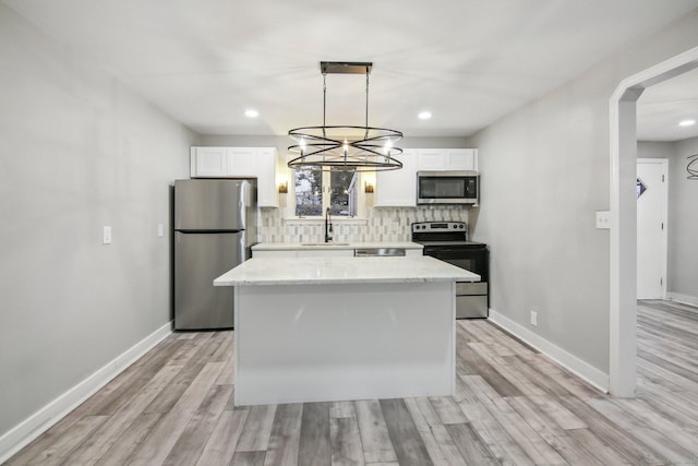 kitchen featuring pendant lighting, sink, white cabinetry, and stainless steel appliances