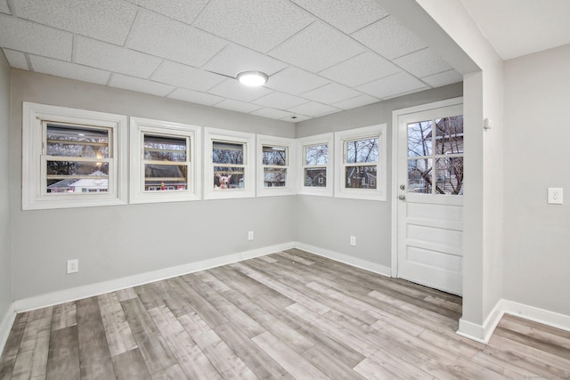 spare room with light wood-type flooring and a drop ceiling